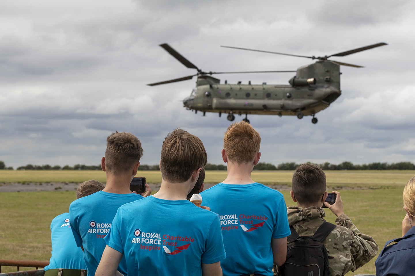 Four cadets watching Chinook aircraft mid-air